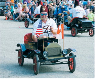 Greg Goodman drives a Kem Shrine mini car during the parade at Mountain’s 127th Deuce of August celebration. Photo by Larry Stokke