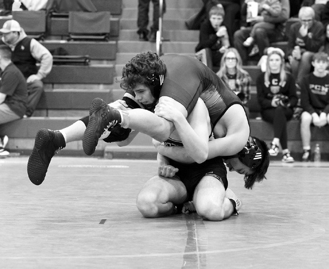 Bryce Carrigan flips his opponent over on his way to winning by a pinfall in Grafton at the Regional competition. Photo by Larry Stokke.