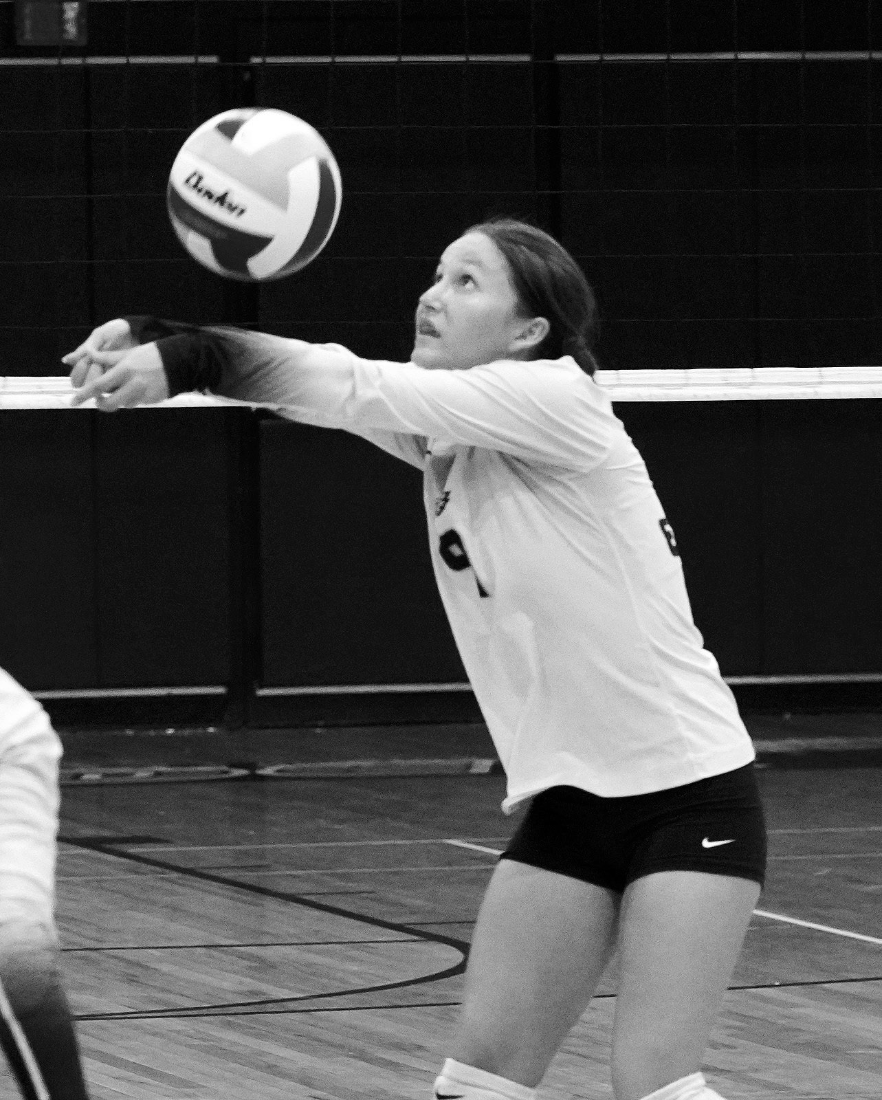Adrienne Longtin with a back row dig against the Cards. Photo by Larry Stokke.