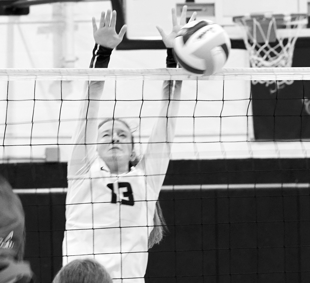 Addison Lyons stuff blocks the ball for a point against the Cards. Photo by Larry Stokke.