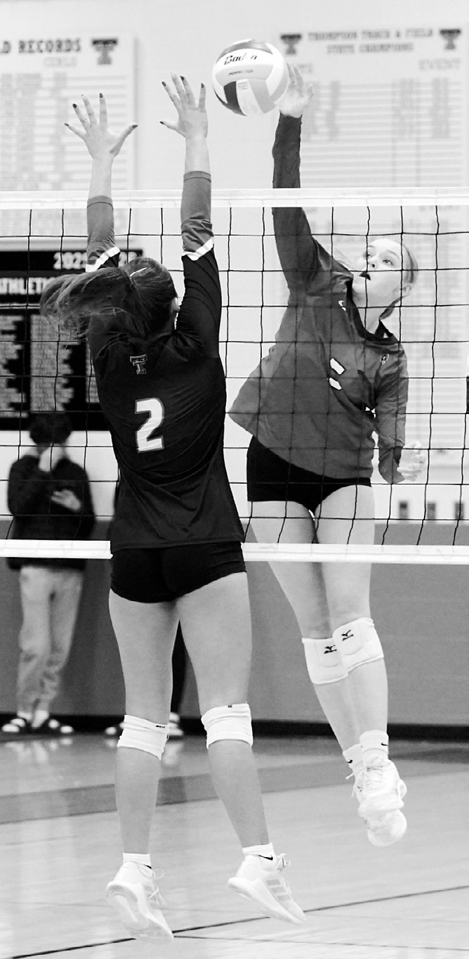 Hallie Overby sends the ball over a Tommies player for a point. Photo by Larry Stokke.