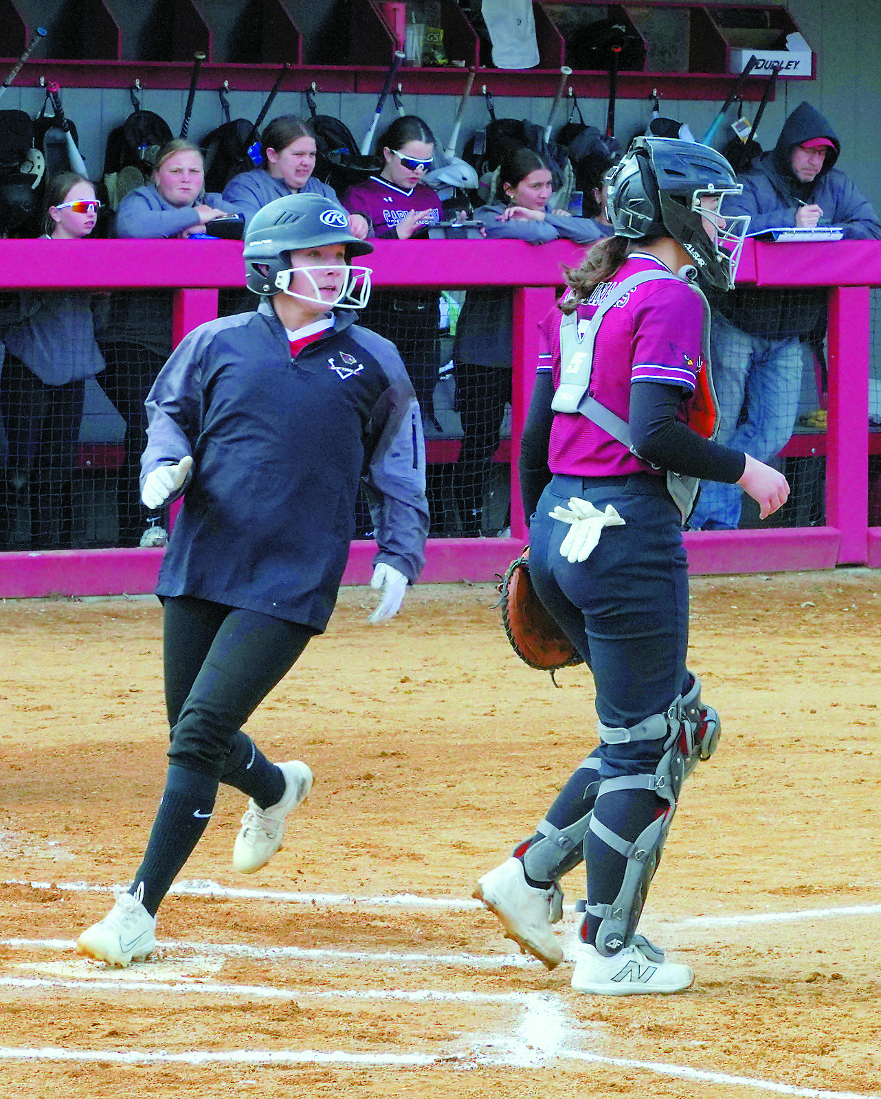 Raeleigh Ratzlaff touches home plate and scores a run for the Lady Cards. Photo by Larry Stokke.