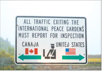 A sign marking the U.S.-Canada border is pictured on a rainy day near Dunseith, North Dakota. (Photo by Mary Steurer/North Dakota Monitor)