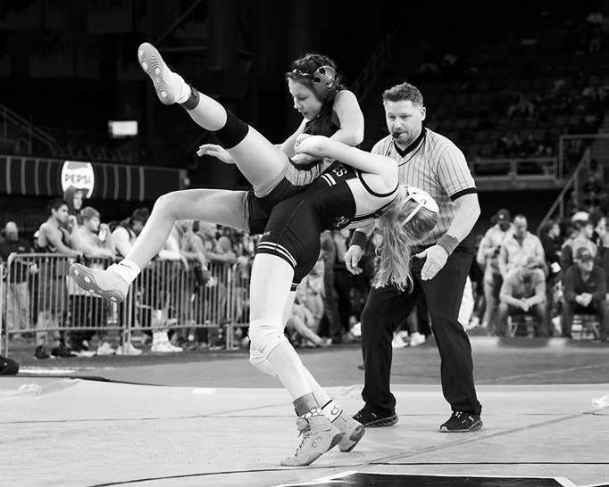Charlotte Crowston powers her girl to the mat and pins her for the win in the 106 lb. weight class. Photo by Larry Stokke.