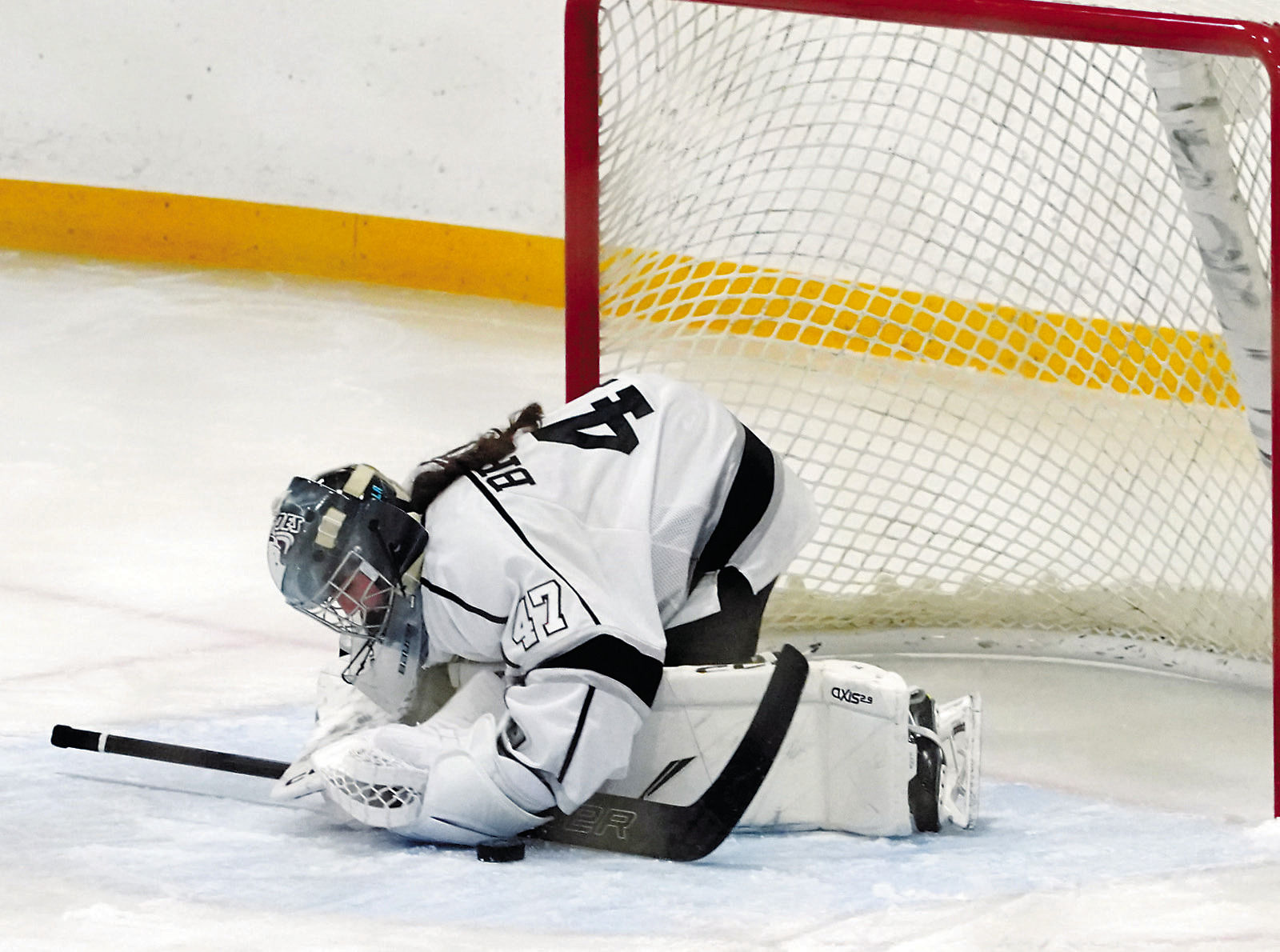 Ella Brekke stops the puck from getting past her and scoring for the Britle Bruiskies. Photo by Larry Stokke.