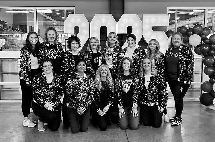 The hockey moms pose for a photo at the State Tournament in Grand Forks. Photo by Jen Busse.