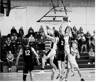 Garret rises above defenders to snag the offensive rebound. Photo by Ashley Schafer