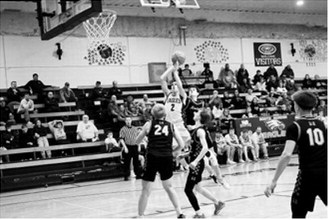 Kaden Moore takes the hit and finishes a tough layup over a defender. Photo by Ashley Schafer
