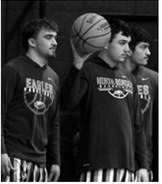 Under the bright lights of their home court, seniors Kade Schafer, Brody Berg, and Colton Bailly take the floor one final time, leaving it all on the court in the last home game of their basketball careers. Photo by Ashley Schafer Kade Schafer pushes the fast break down the court and finishes in transition for the Eagles.