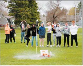 Students watch as a bottle rocket launches into the air during the annual Bottle Rocket Challenge. Teams spent weeks researching, designing and building their rockets before the competition. Photo by Larry Stokke