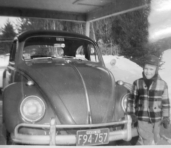 A young Ernie the Three-Legged Clown posing with dad’s VW Bug.