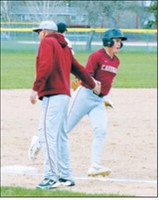 Dawson Downs is congratulated by Coach K as he rounds third base after hitting the first home run of his varsity career during Langdon-Munich’s win over Midway-Minto. Downs finished the game with three RBIs. Photo by Larry Stokke