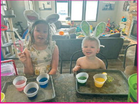 Bailey and Ty smiling and coloring eggs for Easter. Submitted photo.