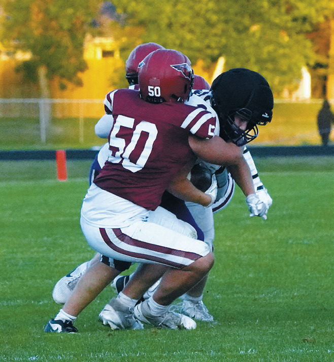 Landon Schneider and a teammate wrap up a Hornet ball carrier. Photo by Larry Stokke.