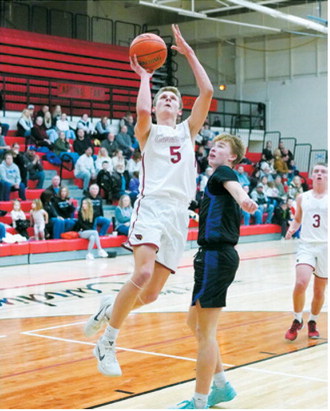 TJ Henderson eyes the basket and drops one in the hole to add 2 points to the Cards score. Photo by Larry Stokke.