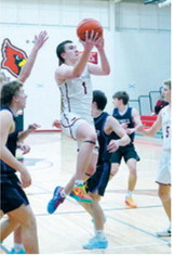 Eastyn Schaefer floats into the lane and drops the ball into the hoop; he finished the game with 28 points. Photo by Larry Stokke.