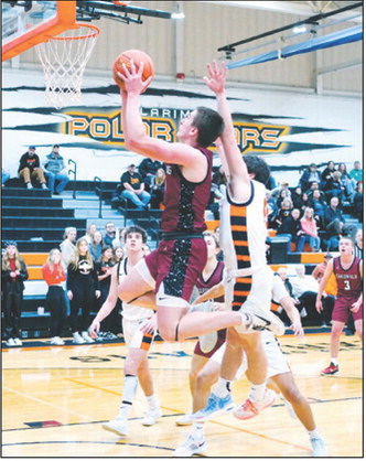 FM Bank Player of the Game Eastyn Schaefer drives to the basket and lays in a basket. He had a team high 20 points in the win over Larimore. Photo by Larry Stokke.