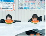 Ready, set, eat! Young competitors dig into slices of watermelon during a watermelon-eating contest at Langdon’s Pre-Blast Bash celebration July 3. Participants raced to finish their watermelon without using their hands. Photo by Larry Stokke