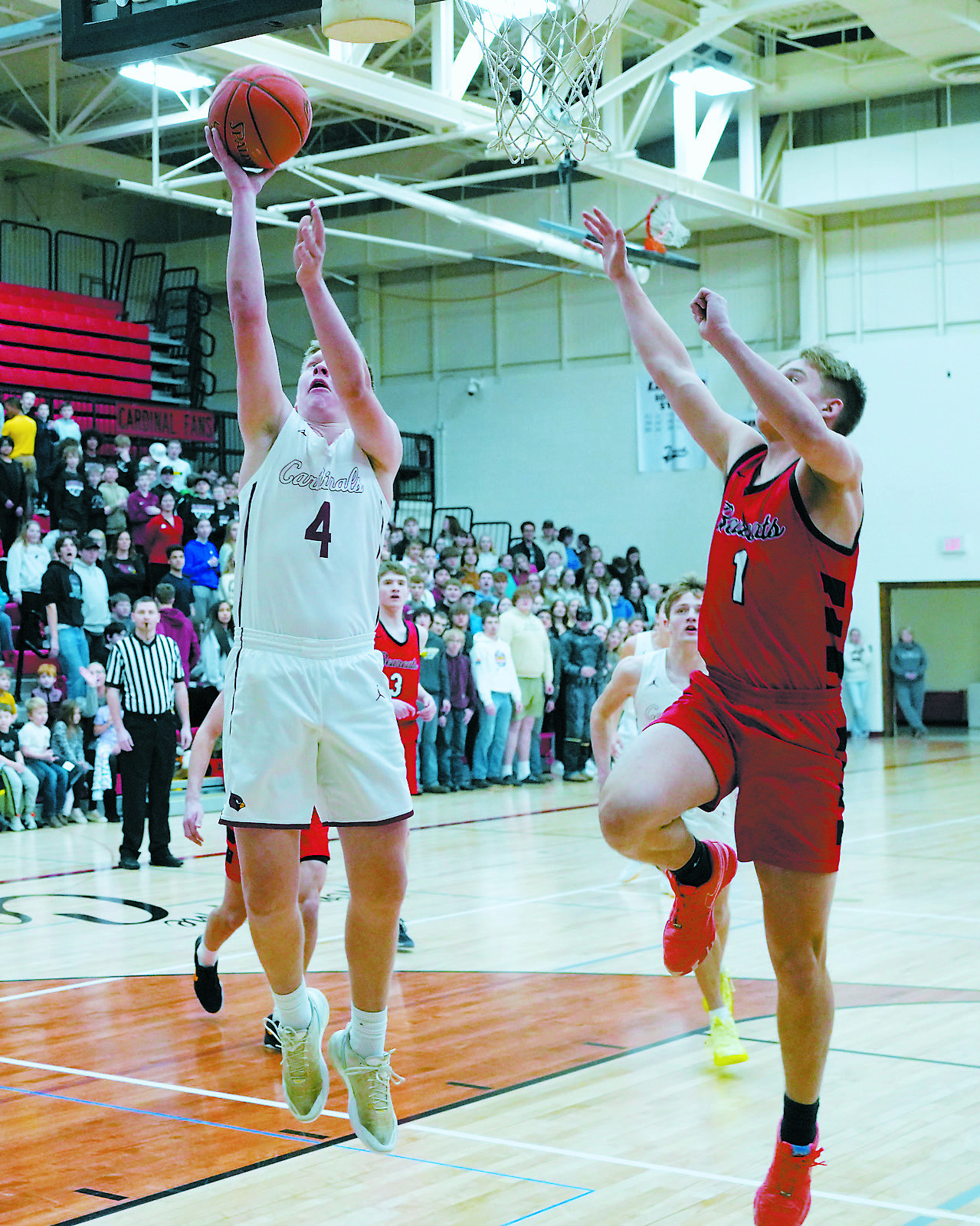 Levi Swanson drives down the lane and sinks a basket. Photo by Larry Stokke.