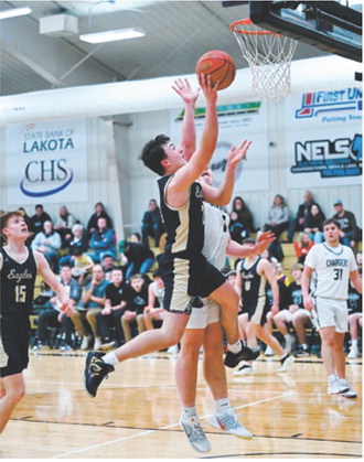 Senior Brody Berg puts up a layup against tough defense from the Chargers. Photo by Ashley Schafer