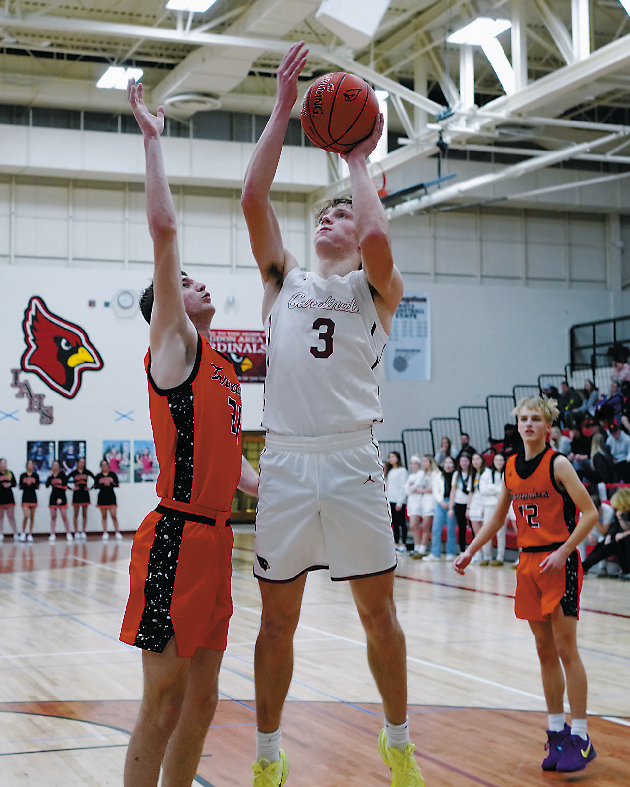 Cody Amble puts up a shot over Ryan Pelletier to finish with a 14-point game. Photo by Larry Stokke.