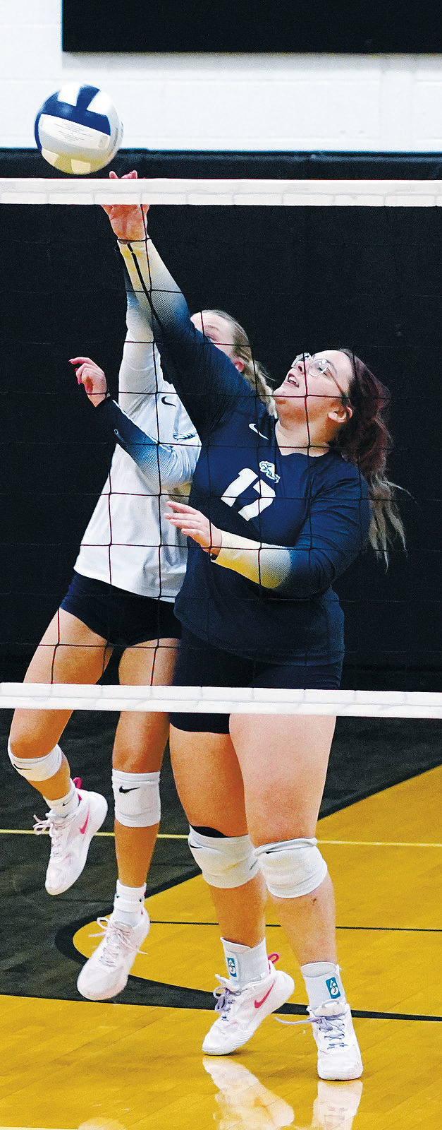 Jaelyn Forrey sends the ball over the net with Caylee Berg right with her. Photo by Larry Stokke.