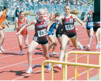 Hallie Overby hands off to Mya Swanson during the 4x400-meter relay taking third place at the NDHSAA Class B State Track and Field Meet. Photo by Larry Stokke