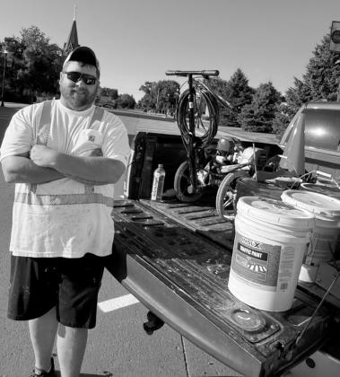 Nate the PMT posing with his Titan PowerLiner 850 line sprayer machine and pails of paint.