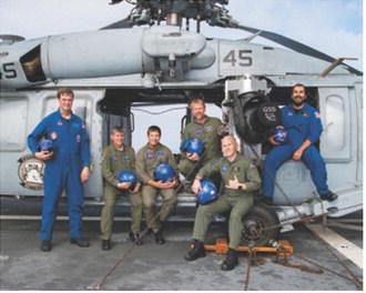 Chris Johnson, standing center, poses with members of the Artemis I recovery team aboard a U.S. Navy vessel following the successful splashdown and recovery of the Orion spacecraft in 2022. Johnson served as part of the Air Operations team during the mission. Photo courtesy of NASA