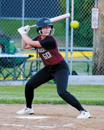 Harper Jacobson keeps her eye on the ball before driving it into the outfield for a base hit during Langdon Area/Munich's victory over Larimore on June 25 in Munich. Photo by Larry Stokke