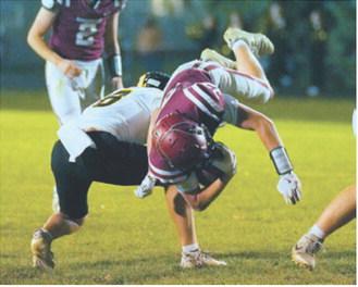 FM Bank Co-Player of the Game Austin Wenzel dives past an Aggies defender for a first down. Photo by Larry Stokke