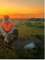 Bailey Samuelson poses with a deer harvested during the youth rifle season, with a beautiful sunset in the background. Photo submitted by Greta Samuelson