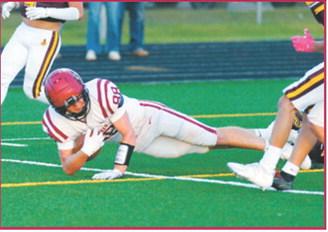 Langdon Area-Munich’s Colten Hein, No. 88, holds onto the ball as he is brought down during the Cardinals’ Sept. 11 game against Turtle Mountain in Belcourt. Photo by Larry Stokke