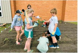 Youth help plant the Cavalier County Community Garden during the first Junior Master Gardener session of the summer. Photo by Jane Hayen
