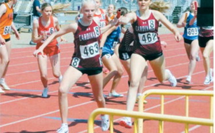Hallie Overby hands off to Mya Swanson during the 4x400-meter relay taking third place at the NDHSAA Class B State Track and Field Meet. Photo by Larry Stokke
