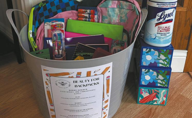 The Honeycomb Hair Salon’s “Beauty for Backpacks” donation bin is filling with supplies for area schools. Throughout August, the salon will donate one school supply for every service booked. Submitted photo.