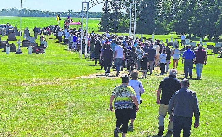 A procession through the cemetery followed the final mass held last Sunday. Reverend Schill discussed how the Our Lady Mt. Carmel Cemetery Fund is currently at $40,000, but needs to be closer to $100,000 to be a viable, lasting foundation. PHOTO BY HILARY NOWATZKI.