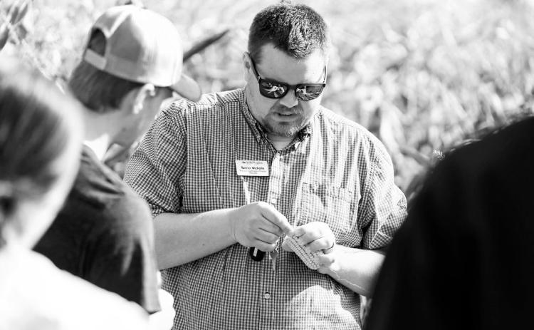 Tanner Nicholls discusses harvest topics with students.