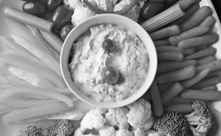 Bring a healthful dish to your next holiday party. How about a veggie tray shaped like a snowman with spinach dip? (photo by Pixabay)
