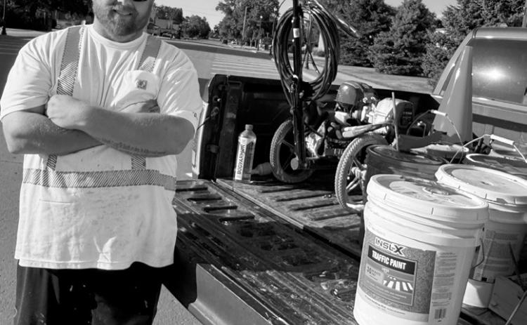 Nate the PMT posing with his Titan PowerLiner 850 line sprayer machine and pails of paint.