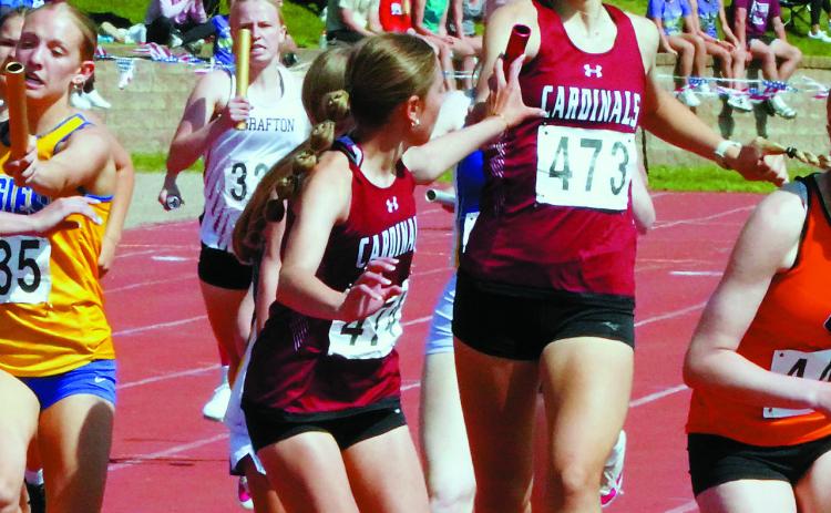 Taya Feist hands the baton to Meggy Hetletved who, along with teammates Hallie Overby and Mya Swanson, had their season best time in the 1600 meter run of 4:12.43. Photo by Larry Stokke.