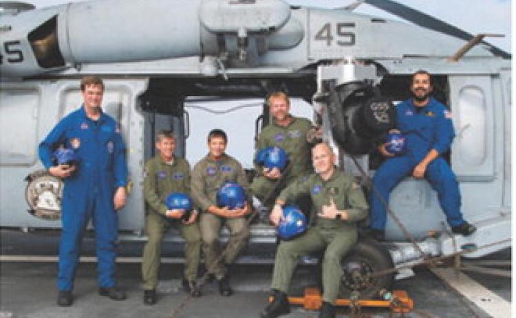 Chris Johnson, standing center, poses with members of the Artemis I recovery team aboard a U.S. Navy vessel following the successful splashdown and recovery of the Orion spacecraft in 2022. Johnson served as part of the Air Operations team during the mission. Photo courtesy of NASA
