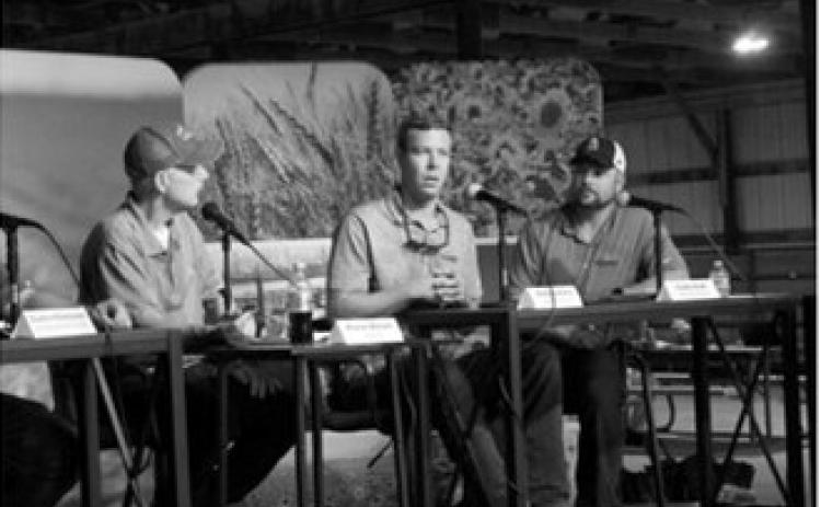 Mark Martens, center, vice president of Agri Placements International, discusses agricultural labor trends and growing demand for H-2A visa workers during a panel at the Big Iron Farm and Construction Show in West Fargo on Sept. 16, 2026. Also pictured are moderator Korrie Wenzel, left, and Caleb Zook. (Photo by Ceilidh Kern/For the North Dakota Monitor)