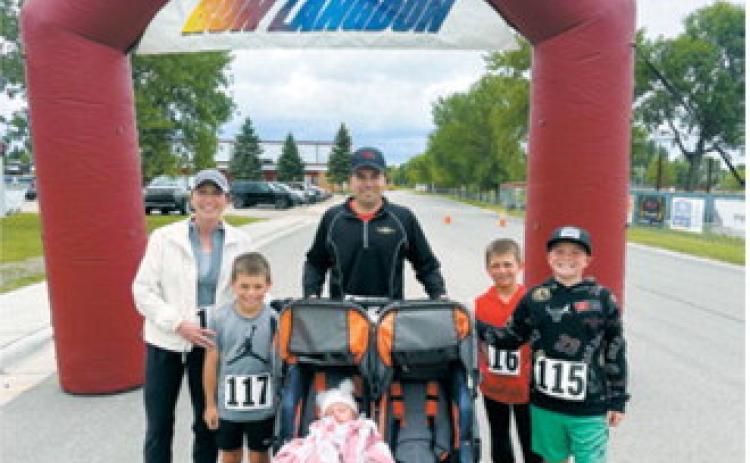Family affair – The Roy family poses beneath the Run Langdon finish arch following the June 13 event in Langdon. Family members participated in the race while the youngest member enjoyed the festivities from a stroller. Submitted photo