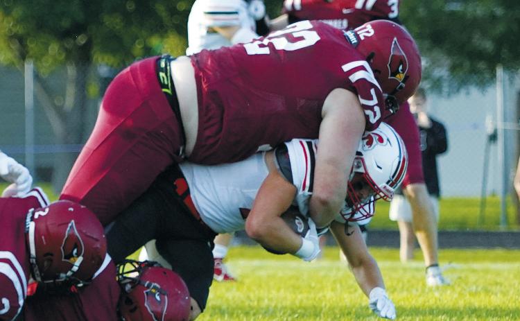 With the help of his teammates, Jacob Lowery stops any forward gain by a Central Cass player. Photo by Larry Stokke.