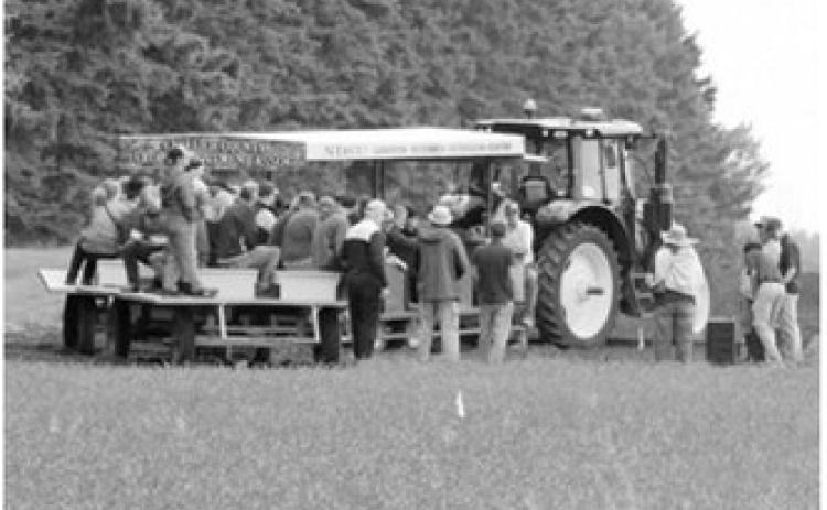 Visitors tour research plots aboard a wagon during the Langdon Research Extension Center Field Day on July 16. The annual event featured updates on crop research, disease management, soil health and varietal trials, along with a stop at the site of the new seed cleaning facility. Photo by Larry Stokke
