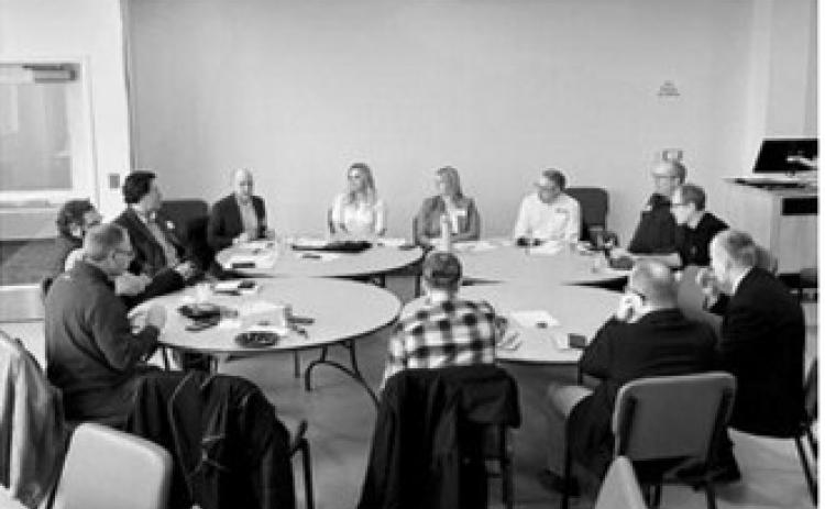 Participants discuss current and future issues impacting agriculture and rural communities at a roundtable held by North Dakota News Cooperative with PolicyLink representative Josh Kirchenbaum, seated to right of Sabrina Halvorson (NDNC CEO, in orange). Photo Rusty Halvorson.