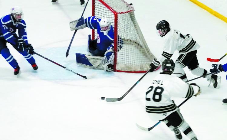 Benjamin Berg brings the puck around the side of the net to try a shot in the Jr Gold game. Photo by Larry Stokke.