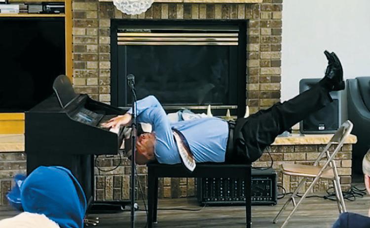 Gordy “Crazy Fingers” Lindquist playing one of his most iconic performances - playing the piano while laying on his back! Photo by Heather Duerre.
