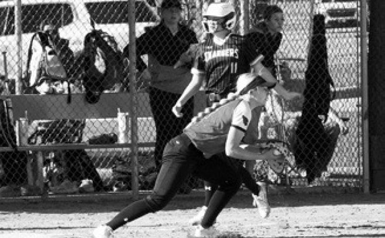 McKenna Schneider puts out the base runner and looks to throw the ball to home plate. Photo by Larry Stokke.